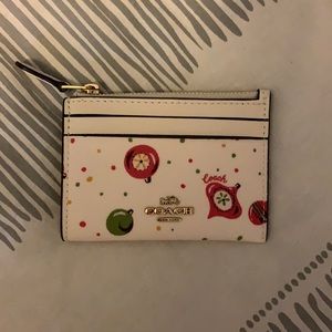 Coach wallet white with Christmas ornaments. Zipper and pockets on the outside